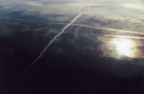 Spiegelung von Kondensstreifen in einem Teich